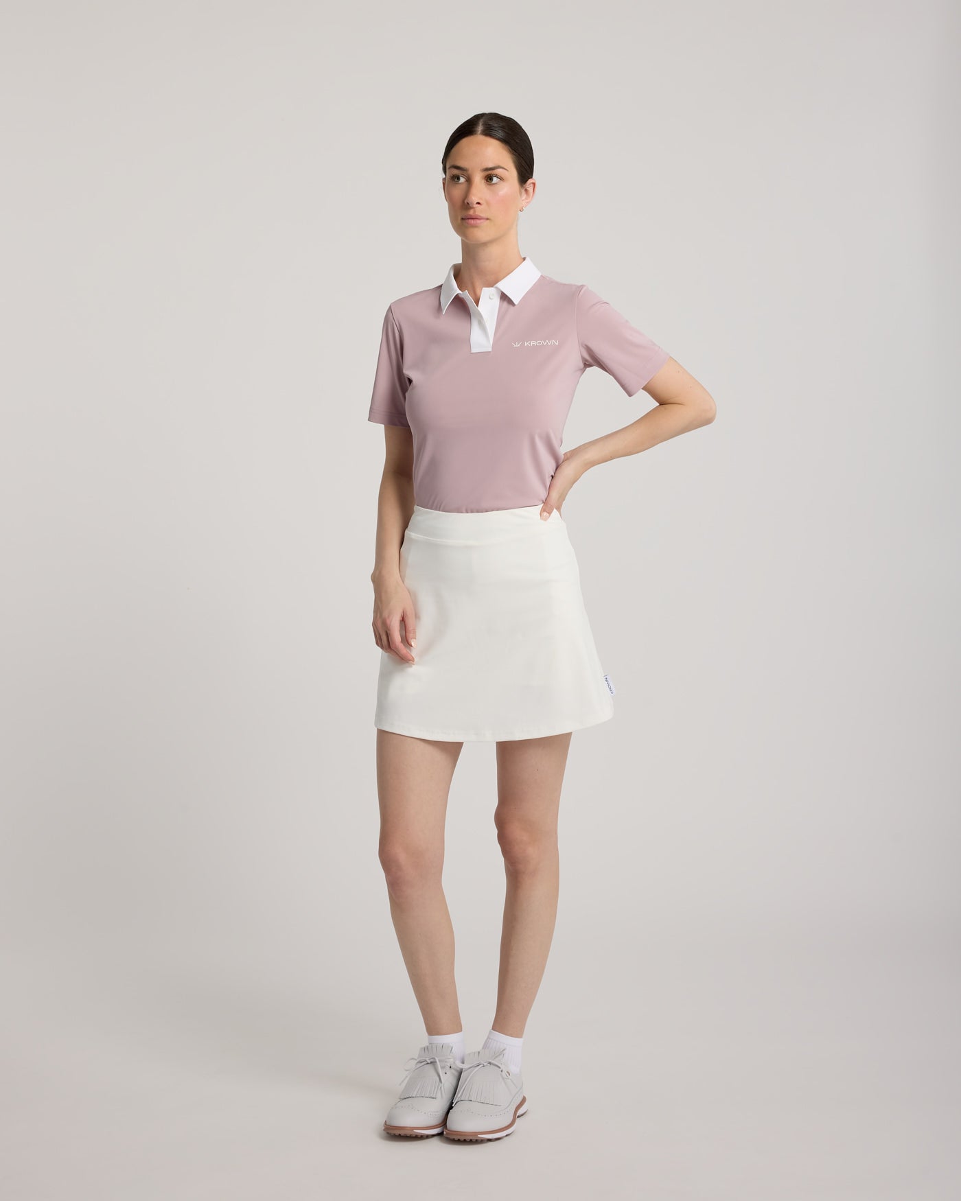 Jupe Lexie KROWN en blanc - vue de face avec polo rose - jupe de golf femme plis avant