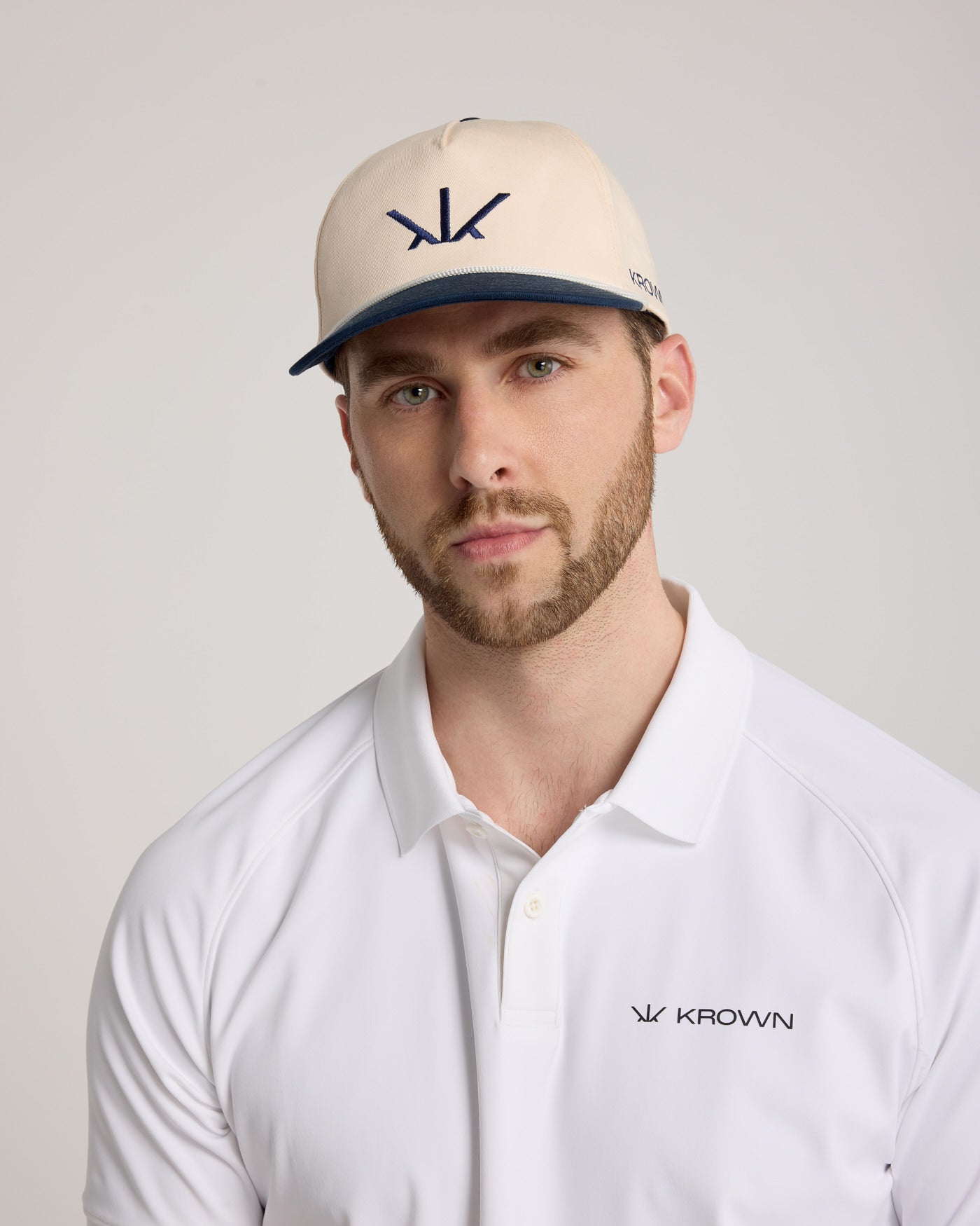 Homme portant la Casquette Héritage Golf Krown beige et marine – style golfeur