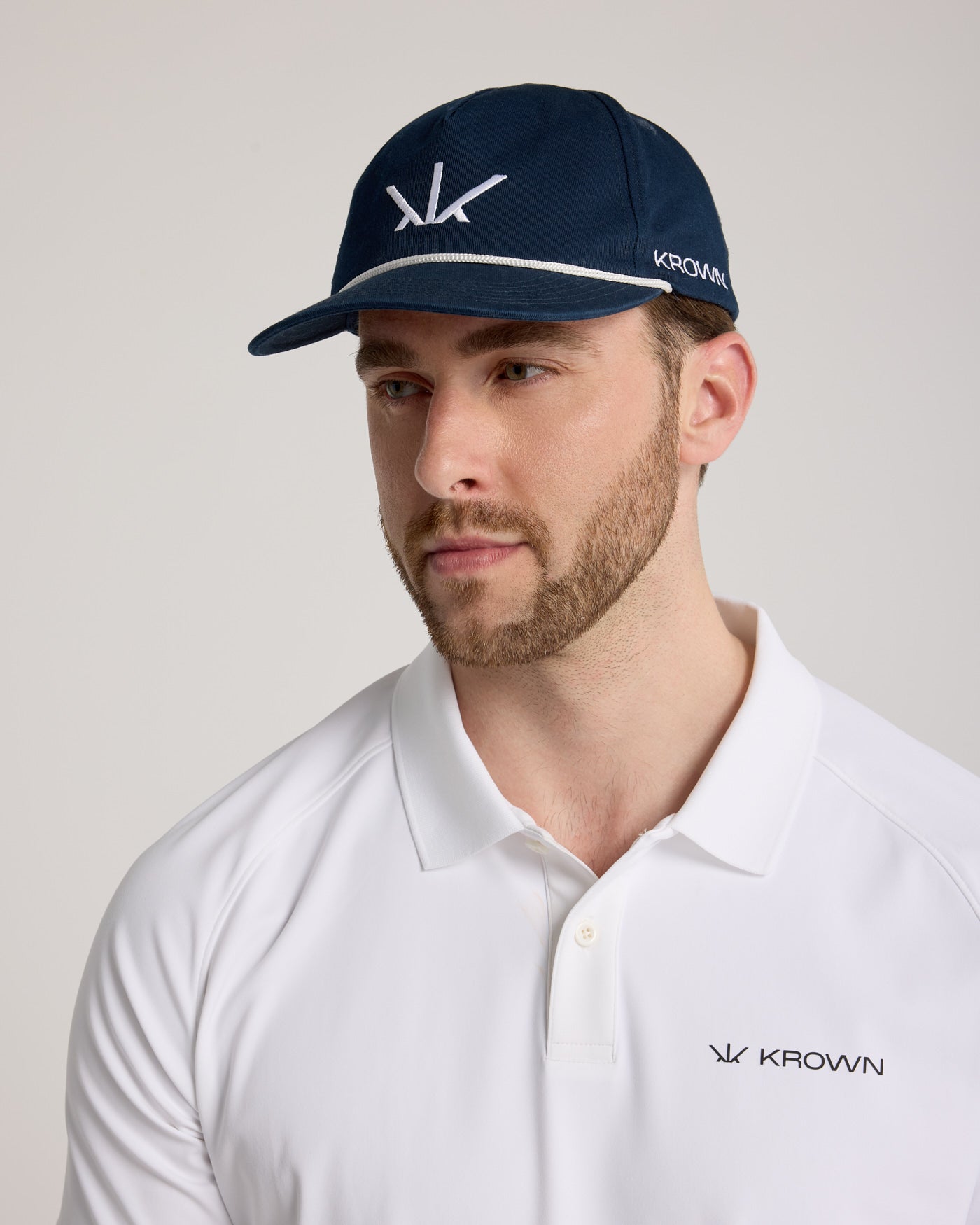 Homme portant la Casquette Héritage Golf Krown marine – logo blanc brodé, style golfeur premium